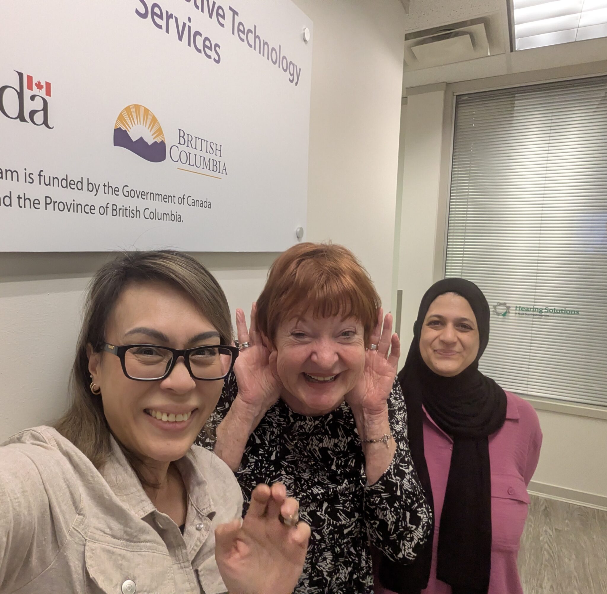 Linda, in between Joanna and Andleeb, poses for a photo in our Burnaby office.