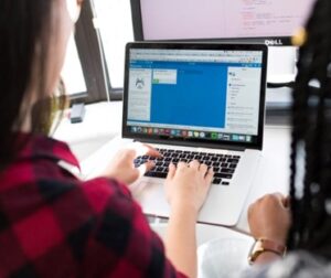 a woman typing on a laptop