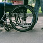 A caregiver pushes a person in a wheelchair.