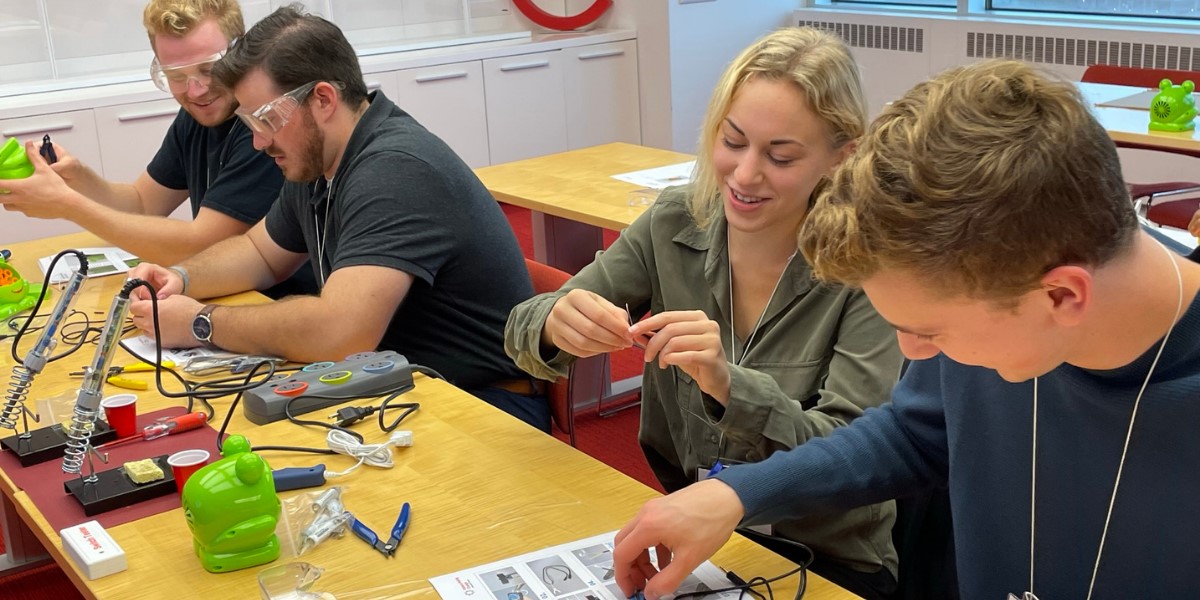 Makers at a build event work on devices.
