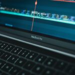 A person uses video editing software on their laptop.