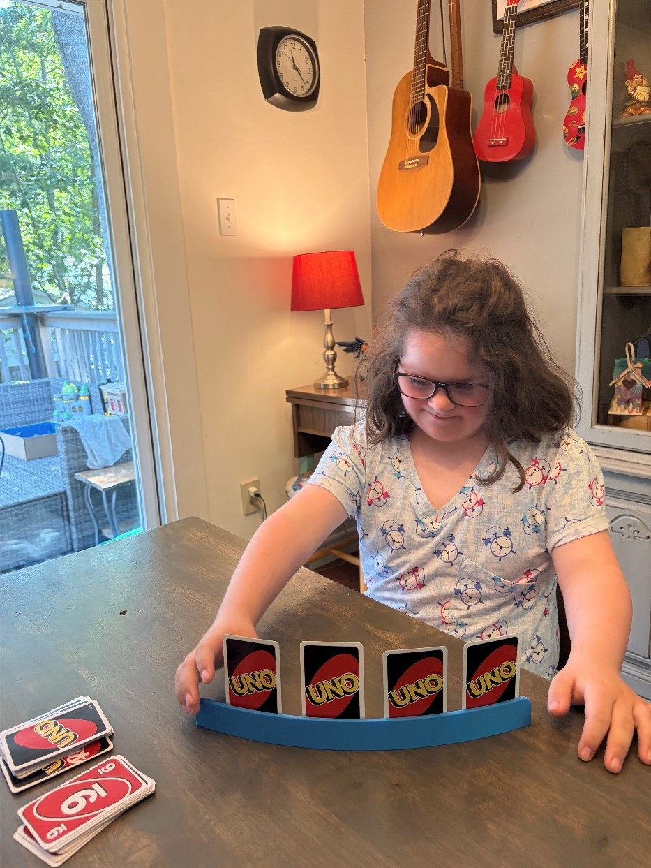 Mira using a Single Row Playing Card Holder to play Uno
