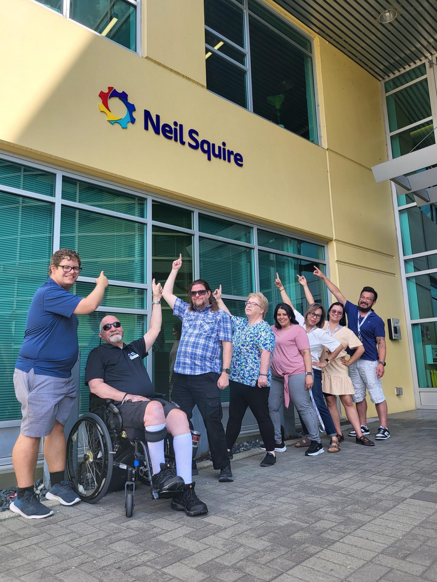 Neil Squire staff point at the new sign.