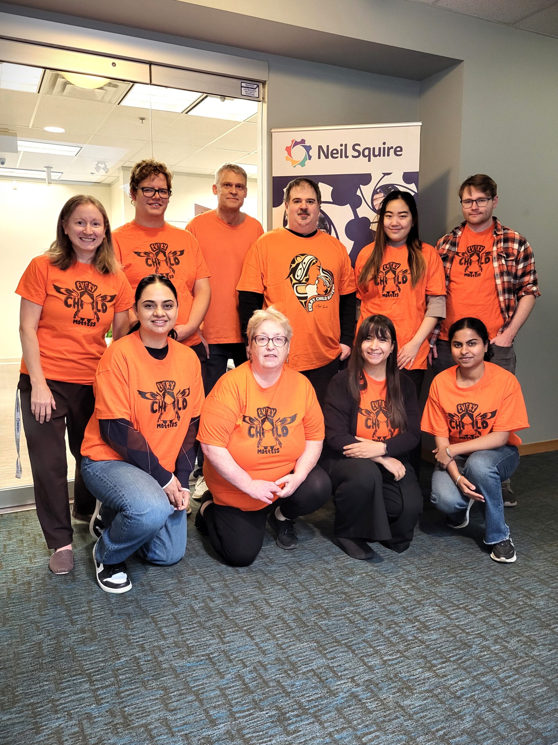 Our Burnaby office wearing orange shirts.