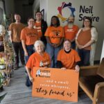 Our Regina office wearing orange shirts that say Every Child Matters and holding a banner that says,