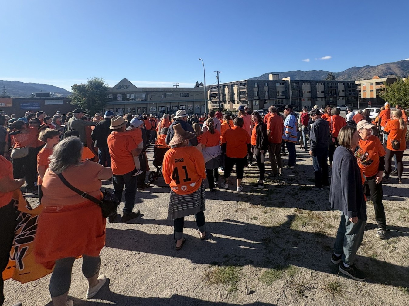 Large group of people wearing orange shirts taking part in the walk.