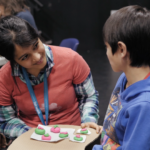 Rashmi working with Timothy, a 10 year old boy with a disability, on a controller that he can use at the Access Makeathon.
