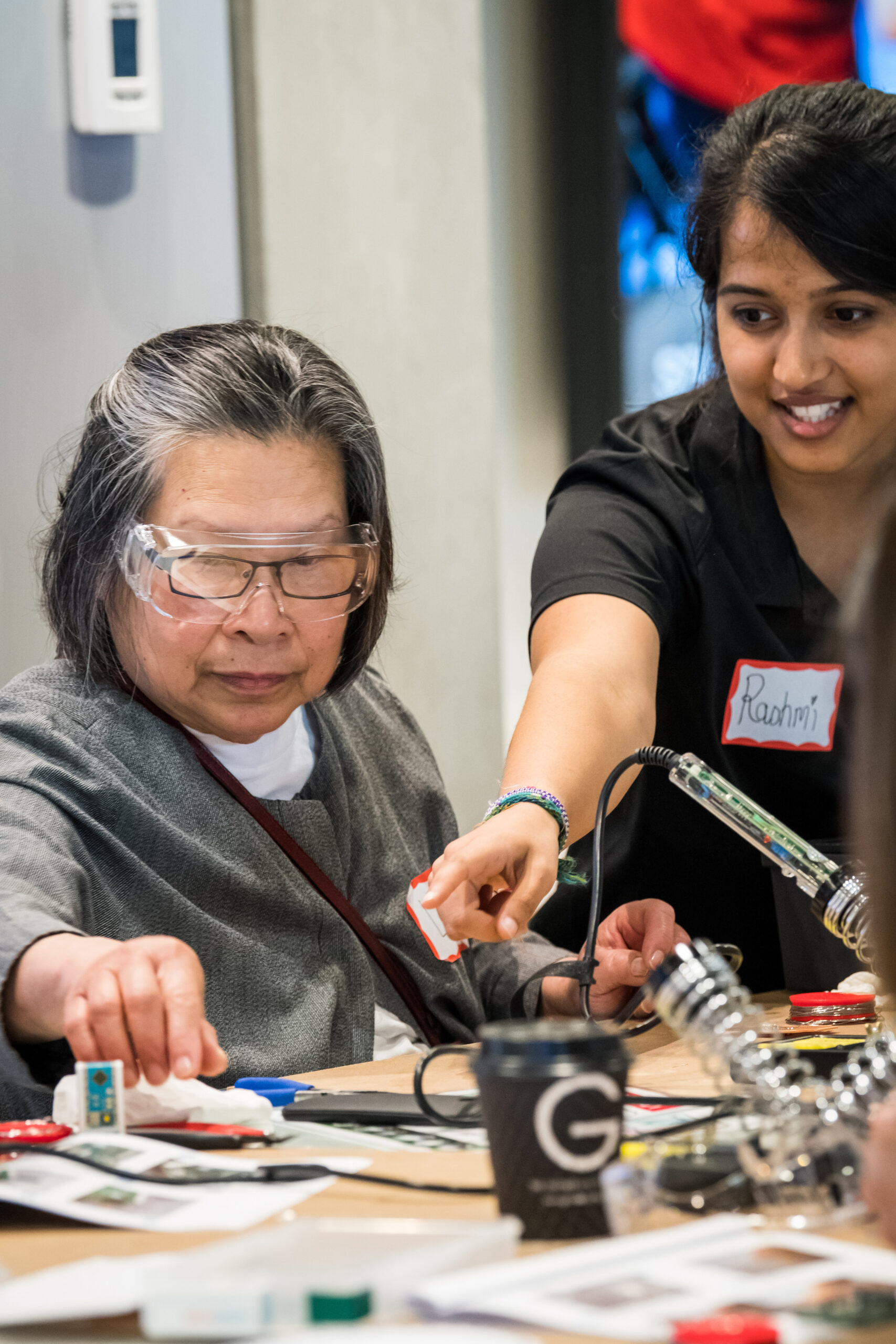 Rashmi helping a volunteer maker at an early Makers Making Change build event.